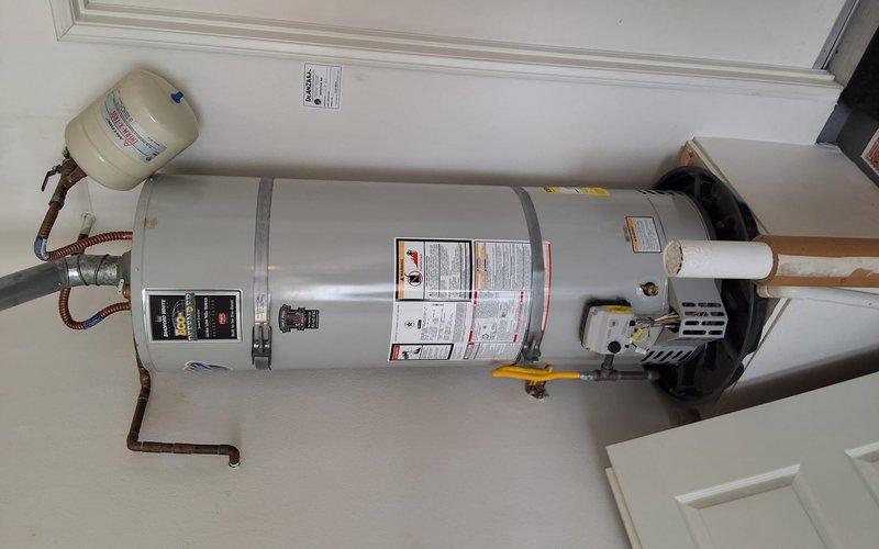 Performed comprehensive maintenance service and safety inspection on 2021 Bradford White URG240T6N atmospheric gas water heater. Completed full tank flush to remove sediment buildup and improve heating efficiency. Conducted thorough safety check including inspection of gas control valve assembly, temperature and pressure relief valve, burner assembly operation, flue venting system, and expansion tank. Verified proper function of all controls, checked for gas leaks at connections, confirmed adequate combustion air supply, and inspected copper water line connections and flexible gas connector for any signs of wear or corrosion. All components found to be operating within manufacturer specifications with no safety concerns identified.