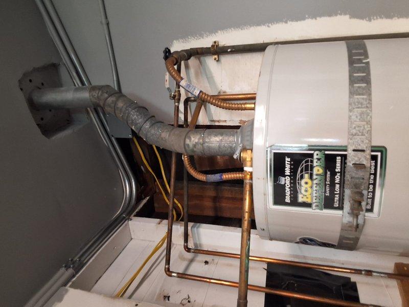 Conducted on-site inspection and estimate for tankless water heater conversion. Evaluated existing water heating system including current tank-style water heater, associated copper piping, and HVAC equipment configuration in mechanical room. Discussed permit requirements for conversion project and available payment options with property owner. Documented existing installation with photographs for estimate preparation.