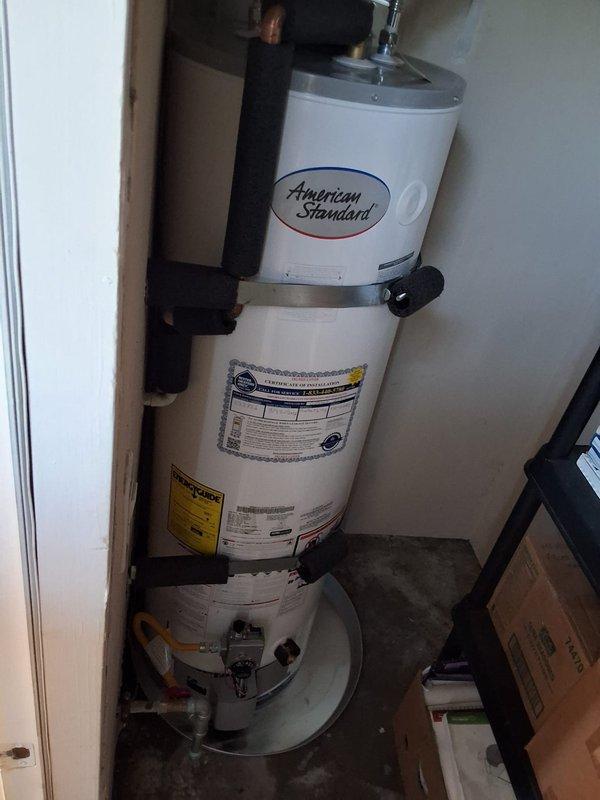 Responded to property management account for reported water heater leak at multi-unit residential property. Upon arrival and evaluation, replaced existing gas water heater with new American Standard unit. New water heater properly secured with metal strapping, connected to existing gas and water lines, and installed on drip pan per code requirements. Coordinated with property management office regarding findings and pricing prior to completing installation work.