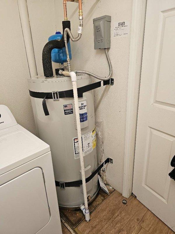 Responded to property management complaint regarding inadequate hot water duration (2-3 minutes only) at rental unit. Performed diagnostic evaluation on Bradford White 50-gallon electric water heater that had previously been serviced by another plumber who replaced the unit under warranty without resolving the issue. Conducted thorough inspection of water heater installation, electrical connections, plumbing configuration, and associated components including water softener system. Examined copper supply lines, PVC drain piping, pressure relief valve, electrical panel connections, and insulated piping. Documented existing installation with photographs showing complete system layout including wall-mounted electrical box, flexible conduit connections, brass fittings, and valve assemblies. Evaluated potential causes including undersized unit for demand, electrical supply issues, thermostat malfunction, sediment buildup, mixing valve problems, or improper installation. Contacted office with