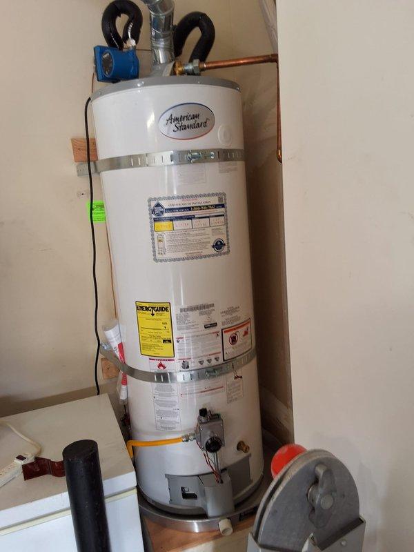 Responded to no hot water complaint on American Standard water heater model GN50T136, serial C25-012976. Upon inspection, unit was approximately one year old and still within labor warranty period. Performed diagnostic evaluation of water heater installed in utility space, checked all plumbing connections, gas line, venting system, and electrical components. Verified proper operation of unit, documented installation with photos showing copper piping connections, blue shut-off valve, metallic safety strap, and venting duct configuration. All manufacturer labels and EcoChoice specifications visible and intact on unit exterior.