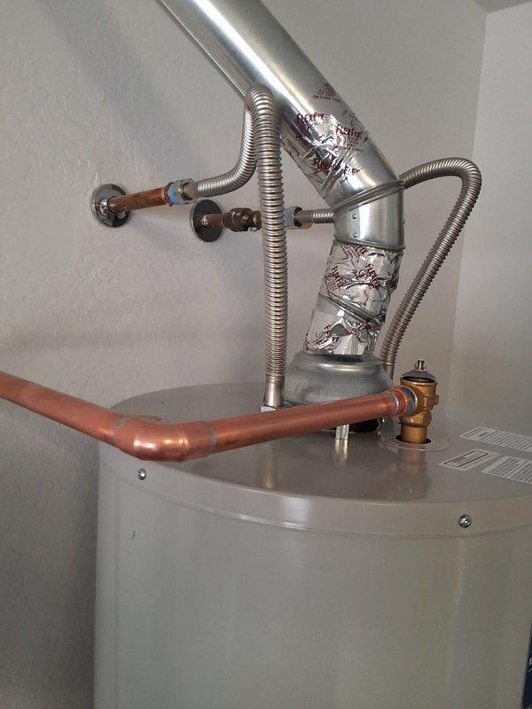 Responded to service call for leaking tank on a 2018 PROG5040N residential gas water heater. Successfully removed and replaced the failed unit with a new 40-gallon gas Bradford White water heater, including proper venting installation with metallic ductwork, copper supply line connections with brass fittings and temperature/pressure relief valve, and yellow flexible gas line hookup. Installation completed within promised arrival window with all connections tested and verified leak-free.