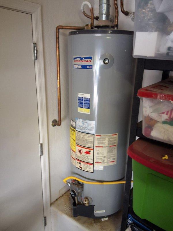 Responded to service call for leaking 40-gallon tall gas water heater (model BFG6240T) located in garage. Upon inspection, confirmed active leak and severe rust corrosion on tank base and mounting components, indicating tank failure. Performed complete removal of failed unit and installed new 40-gallon gas water heater. Connected copper supply lines, flexible gas connector with yellow-jacketed gas line, and verified proper venting. Tested all connections for leaks, confirmed gas valve operation, and ensured unit achieved proper ignition and heating cycle. New American-brand water heater installed and fully operational with all safety labels and specifications visible.
