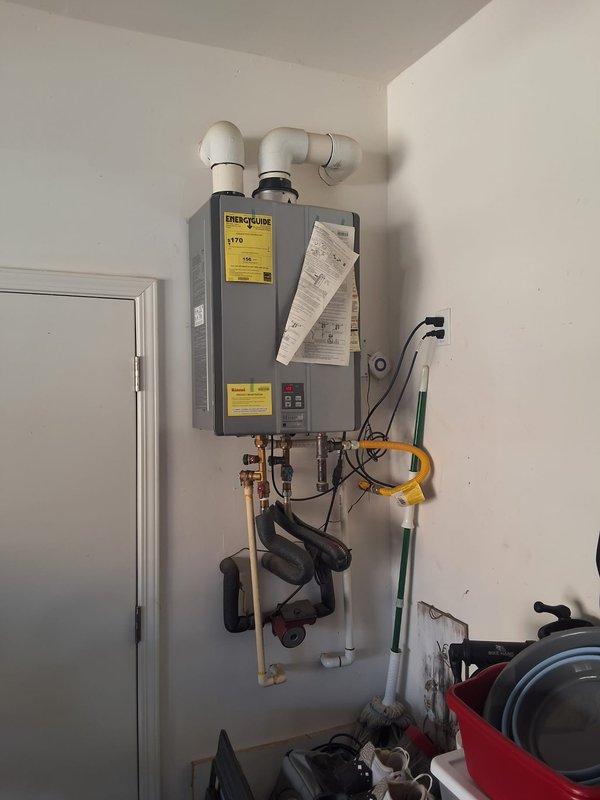 Responded to property management call for Rinnai RUC90I tankless water heater displaying error code 10. Upon arrival, performed diagnostic evaluation of the unit and documented current conditions with photographs showing the wall-mounted installation, control panel displaying temperature reading of 129°F, copper supply lines with shutoff valves, PVC venting configuration, and all associated plumbing connections. Completed onsite assessment and contacted office with findings per property management protocol for pricing approval before proceeding with any repairs.