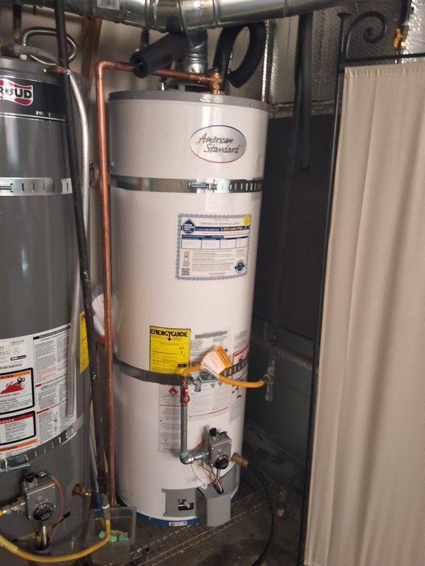 Completed warranty follow-up service on American Standard water heater installation by installing Grundfos comfort pump with proper copper piping connections and flow meter integration. Verified installation of second anode rod and applied appropriate manufacturer specification labels and stickers to unit as required for warranty compliance.