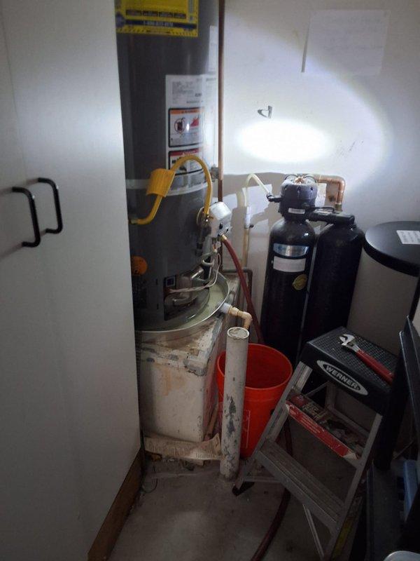 Responded to service call for leaking residential water heater. Upon inspection, found 2015 Rheem 50-gallon natural gas water heater (Model XG50T12HN36U0, Serial M291509380) with active leak and visible corrosion on tank exterior. Due to age and condition of unit, recommended full replacement rather than repair. Discussed permit requirements with customer and provided ballpark estimate for complete installation. Scheduled appointment window and documented existing equipment specifications including 36,000 BTU/H input rating and 150 PSI maximum working pressure. Photographed existing installation showing water heater location in utility room alongside water softener system, noting copper supply connections and proper venting configuration for reference during replacement work.