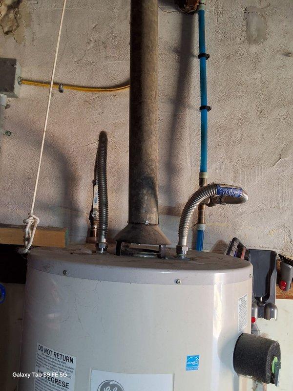 Responded to no hot water complaint on a 7+ year old gas water heater. Upon inspection, identified failed 40-gallon gas water heater (Model: SG40T12AVG00, Serial: 2009 GELN0210V06842) requiring complete replacement. Removed existing unit and installed new gas-fired water heater in basement utility area. Connected all water supply lines using copper piping, installed new gas line connections with flexible yellow gas supply, and properly vented unit with flue pipe assembly. Installed TPR valve with discharge piping per code requirements. Tested all connections for leaks, verified proper gas combustion, and confirmed hot water delivery throughout residence. Advised customer of permit requirements for installation and coordinated scheduling to expedite service completion.
