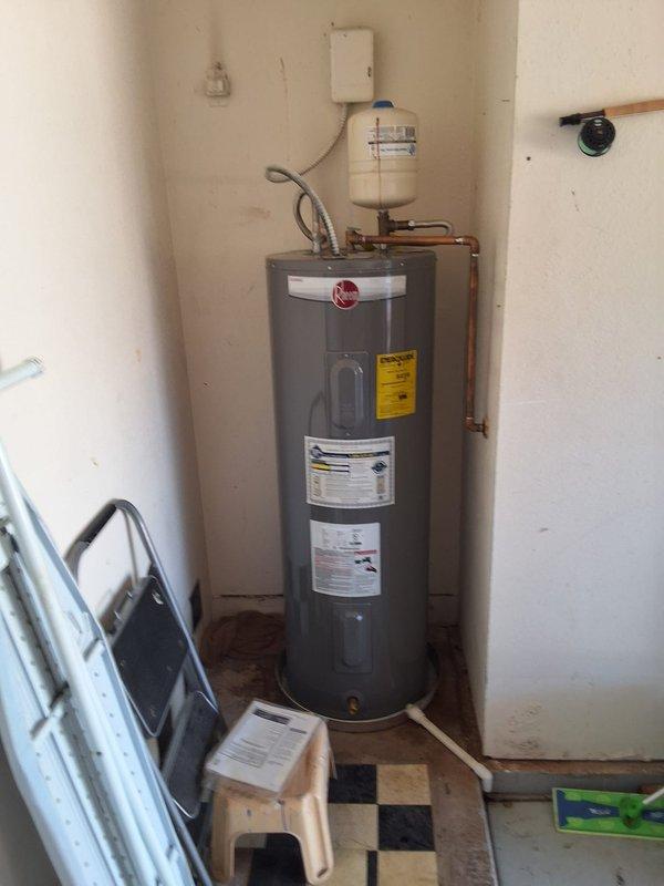 Responded to service call for water heater leaking from top connections. Upon arrival, inspected 50-gallon electric water heater model PROE50T2, serial number M481912477, originally installed in 2020. Diagnosed active leak originating from upper plumbing connections. Tested pressure relief valve and expansion tank functionality. Verified unit is operating beyond warranty coverage period. Presented customer with repair options including replacement of failed components and parts, as well as full unit replacement option with 50-gallon electric model RG150T6N. Documented existing installation with photographs showing water heater configuration, copper supply lines, expansion tank mounting, and pressure gauge readings. Customer to advise on preferred course of action for leak resolution.