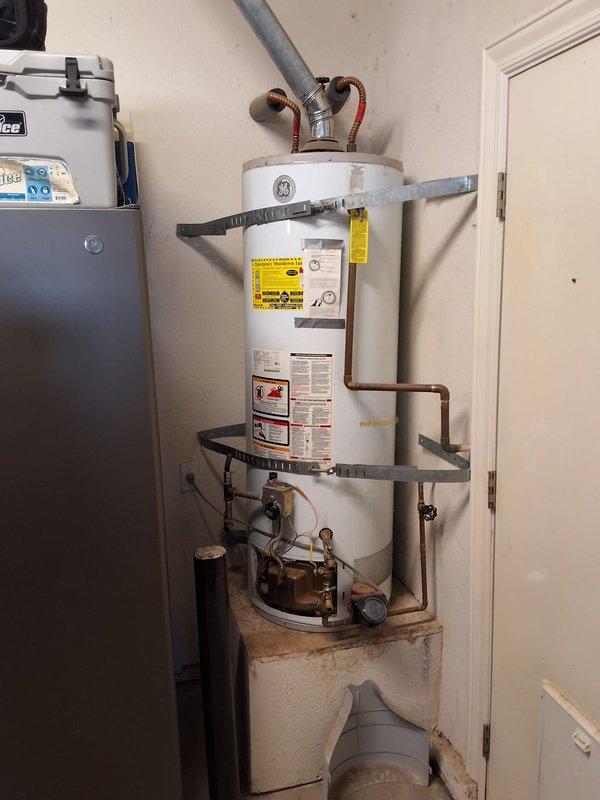 Replaced existing 50-gallon gas water heater (originally installed in 2012) with new GE 50-gallon residential gas water heater. Removed old unit and recirculation pump system, installed new water heater with proper seismic strapping, connected gas supply line with flexible connector, attached hot and cold water copper supply lines, and installed new temperature and pressure relief valve with discharge pipe. Verified all connections for leaks, tested gas valve operation, lit pilot light, and confirmed proper combustion and venting through existing B-vent system. Unit secured to wall with dual earthquake straps per code requirements and all safety labels properly displayed.