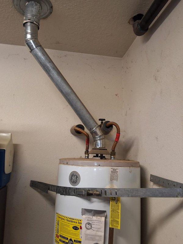 Replaced existing 50-gallon gas water heater (originally installed in 2012) with new GE 50-gallon residential gas water heater. Removed old unit and recirculation pump system, installed new water heater with proper seismic strapping, connected gas supply line with flexible connector, attached hot and cold water copper supply lines, and installed new temperature and pressure relief valve with discharge pipe. Verified all connections for leaks, tested gas valve operation, lit pilot light, and confirmed proper combustion and venting through existing B-vent system. Unit secured to wall with dual earthquake straps per code requirements and all safety labels properly displayed.
