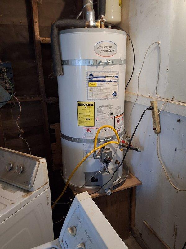 Performed inspection and consultation for 40-gallon American Standard gas water heater currently located in garage being converted to living space. Evaluated existing installation including gas line connections, venting system, and mounting configuration to determine compliant relocation or replacement options. Discussed multiple solutions with homeowner including tankless water heater conversion, electric water heater replacement, exterior shed installation for existing tank relocation, and code requirements for each option to ensure proper clearances and safety compliance for the converted living space.