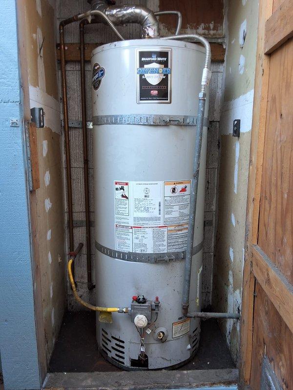 Responded to service call for leaking 40-gallon gas water heater. Performed inspection of existing Bradford White Defender model unit installed in utility closet with tight clearance. Documented current installation including gas line connections, copper water piping, temperature and pressure relief valve, exhaust venting, and overall unit condition. Provided estimate for replacement with new 40-gallon gas water heater, discussed permit requirements, and reviewed available payment options.