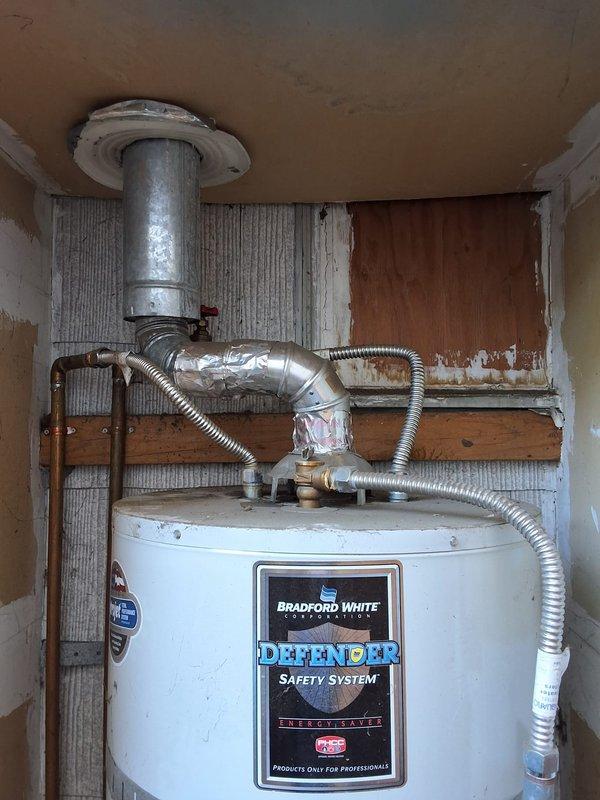 Responded to service call for leaking 40-gallon gas water heater. Performed inspection of existing Bradford White Defender model unit installed in utility closet with tight clearance. Documented current installation including gas line connections, copper water piping, temperature and pressure relief valve, exhaust venting, and overall unit condition. Provided estimate for replacement with new 40-gallon gas water heater, discussed permit requirements, and reviewed available payment options.