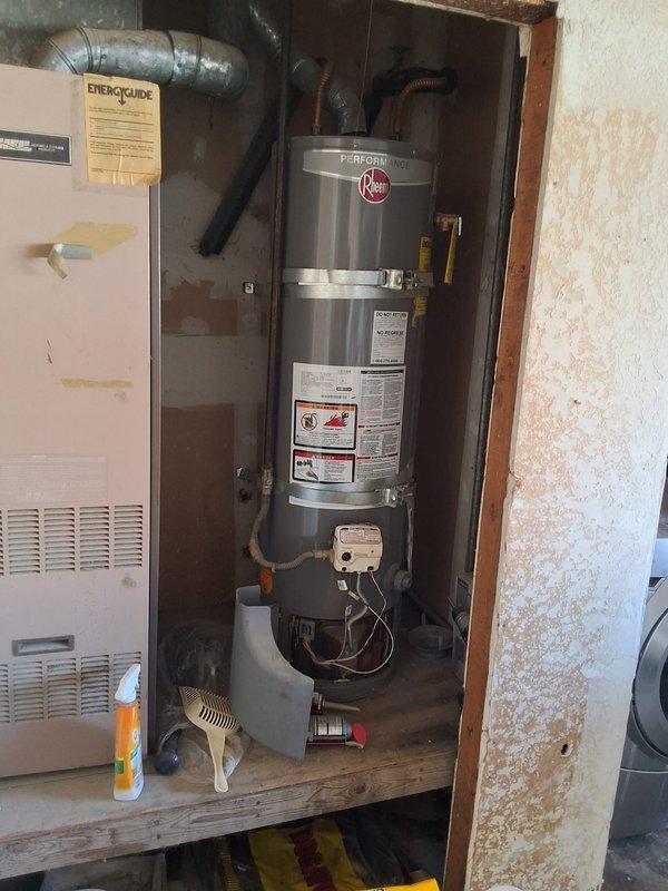 Inspected 10-year-old Rheem 28-gallon gas water heater (Model XG28T06, Serial M391500037, manufactured September 2015) per customer request for replacement evaluation. Provided estimate for replacement with either 40-gallon or 50-gallon gas water heater unit, discussed permit requirements, and documented existing installation with photographs showing current equipment condition and utility closet configuration.