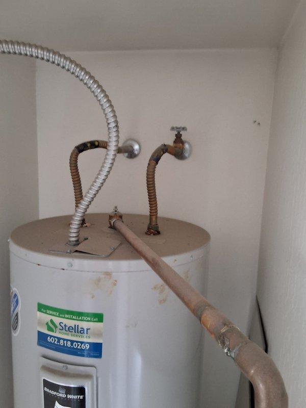 Completed inspection of 50-gallon electric water heater showing visible signs of age including rust staining at base and top connections. Provided estimate for water heater replacement, discussed permit requirements, available payment options, and documented existing installation with photographs showing current plumbing connections and utility closet configuration.
