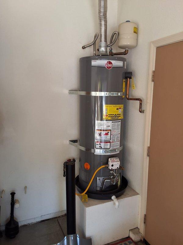 Responded to service call for installation of customer-supplied burner control assembly on residential water heater. Unit identified as Rheem PROG50-38URH6ECI-1, serial number M062105429. Successfully removed existing gas valve control assembly and installed replacement burner control unit provided by customer. Verified all gas connections were secure and tested for leaks using approved methods. Confirmed proper operation of new control assembly including pilot ignition, main burner operation, and temperature regulation functionality. Cycled unit through multiple heating cycles to ensure reliable performance. Inspected all associated components including yellow flexible gas supply line, water connections with gray flexible connectors, brass fittings, and PVC discharge piping. Verified proper venting and clearances around unit installed in utility closet on elevated white platform with black drip pan. All safety controls tested and functioning within manufacturer specifications. Unit re