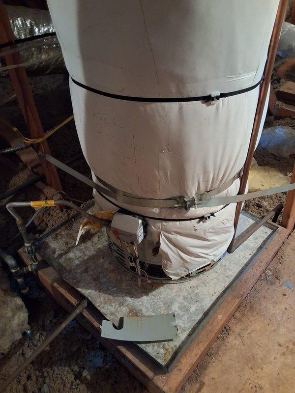 Responded to service call for inspection of existing 50-gallon gas water heater located in attic with insulation blanket. Unit age and model information unavailable due to insulation covering. Assessed installation and discussed replacement options including tankless versus standard tank water heater configurations. Provided technical recommendations and permit requirements for proposed replacement work.