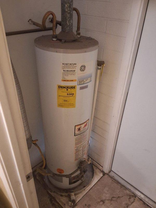 Replaced a 16-year-old leaking 50-gallon gas water heater with a new 50-gallon gas unit. Removed the failed water heater, which showed significant deterioration and corrosion on piping and components, and installed a new GE water heater on a metal base platform. Connected copper supply lines and gas piping, ensured proper venting installation, and verified all connections for safe operation.