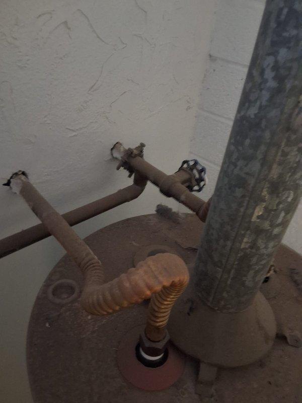 Replaced a 16-year-old leaking 50-gallon gas water heater with a new 50-gallon gas unit. Removed the failed water heater, which showed significant deterioration and corrosion on piping and components, and installed a new GE water heater on a metal base platform. Connected copper supply lines and gas piping, ensured proper venting installation, and verified all connections for safe operation.