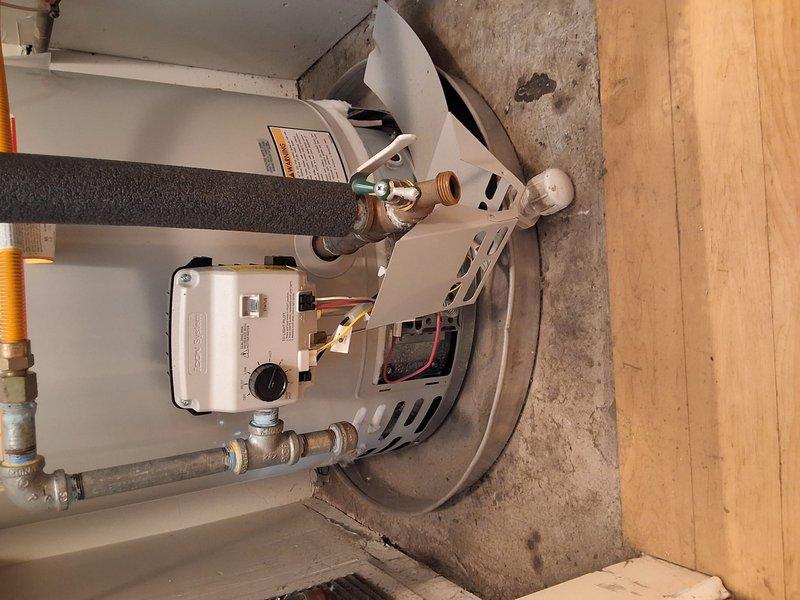 Performed inspection and provided replacement estimate for 9-year-old 50-gallon gas water heater, model URG250H6N, serial number NM38758102, originally installed by our company. Discussed permit requirements and presented two replacement options: upgrading to the same URG250H6N model or installing a standard 50-gallon gas unit. Documented existing installation with photographs showing current plumbing connections, gas line, pressure relief valve, and overall unit condition in utility closet location.