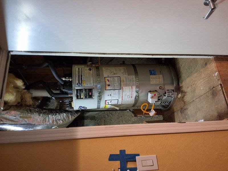 Responded to inspect Bradford White Defender water heater (model URG1PV50S6, serial XL4889576) that was previously installed and exposed to flooding from fire sprinkler system discharge. Upon arrival, performed comprehensive inspection of unit and all connections in utility closet. Verified water heater was producing hot water as reported. Conducted visual examination of tank exterior, checking for water damage, corrosion, or compromised insulation from flood exposure. Inspected all plumbing connections at top of unit, including hot and cold water lines with foam insulation and brass fittings. Examined gas line connections and control valve. Checked flue pipe and venting system for proper operation. Verified electrical connections and safety switches remained secure and functional. Assessed surrounding area including exposed insulation and structural components for moisture damage. Documented unit condition with photographs showing tank, piping configuration, and installation environme