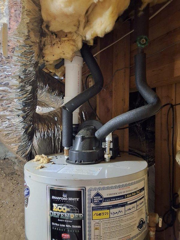 Responded to inspect Bradford White Defender water heater (model URG1PV50S6, serial XL4889576) that was previously installed and exposed to flooding from fire sprinkler system discharge. Upon arrival, performed comprehensive inspection of unit and all connections in utility closet. Verified water heater was producing hot water as reported. Conducted visual examination of tank exterior, checking for water damage, corrosion, or compromised insulation from flood exposure. Inspected all plumbing connections at top of unit, including hot and cold water lines with foam insulation and brass fittings. Examined gas line connections and control valve. Checked flue pipe and venting system for proper operation. Verified electrical connections and safety switches remained secure and functional. Assessed surrounding area including exposed insulation and structural components for moisture damage. Documented unit condition with photographs showing tank, piping configuration, and installation environme
