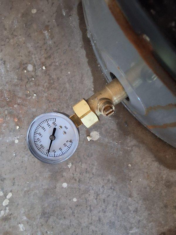 Responded to warranty service call for Rheem 50-gallon electric water heater model PROE05T2RH95 reporting water leakage at base of unit. Performed diagnostic testing using digital multimeter to check electrical components and verify proper voltage readings of 24.24V at control panel. Conducted pressure testing with gauge to assess tank integrity and identify source of leak. Upon inspection, confirmed active water leakage originating from lower section of tank near heating element area. Verified unit is covered under active 10-year manufacturer warranty with documentation on file. Documented findings with photos showing electrical diagnostics and pressure testing equipment. Recommended tank replacement under warranty coverage due to compromised tank integrity and active leak condition that cannot be repaired.