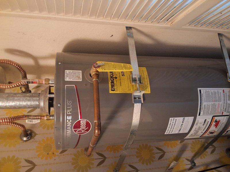 Replaced leaking 40-gallon gas water heater, over 10 years old, located in laundry room. Installed new Rheem Performance Plus model GN40T1-3-6 with 12-year warranty, including proper copper piping connections, flexible gas line installation, and seismic strapping per code requirements. Permitting was discussed and offered to customer for compliance with local building regulations.