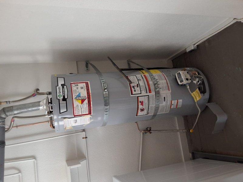 Replaced out-of-warranty 40-gallon gas water heater with new A.O. Smith model GN40T1-3-6. Removed existing unit, installed replacement water heater with proper venting, gas connections, and water supply lines, secured unit with seismic straps, and installed drain pan for leak protection.