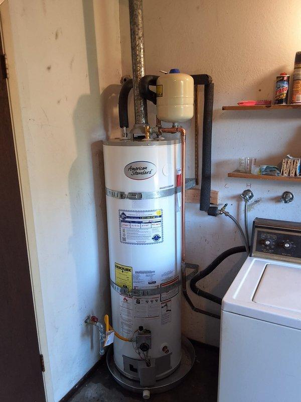 Removed the existing 20-year-old 40-gallon gas water heater, which had a failed burner assembly, and installed a new 40-gallon atmospheric-vent gas water heater (model GN40T1-3-6) with a 12-year warranty. The new unit was set on a drain pan and connected to the gas supply with a shutoff valve, water supply lines, and the existing galvanized vent, with an expansion tank in place on the supply side. Leak-checked all gas and water connections, verified proper ignition, burner operation, and venting, and cleaned the work area.