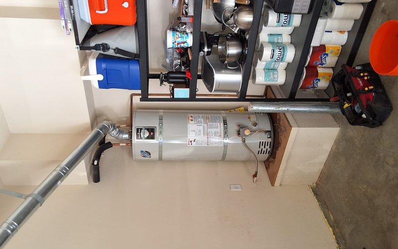 Responded to a bottom-leaking 50-gallon gas water heater and replaced it with a new 50-gallon gas unit, including a permit for the installation. The failed tank was drained, disconnected from the water, gas, and flue connections, and removed. The new heater was set on its platform, then reconnected to the copper supply lines, gas control valve, and vent piping, and secured per code.