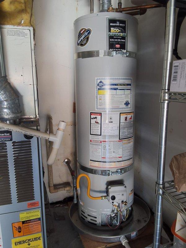 Responded to a warranty callback for a recurring Error Code 10 lockout on a Bradford White gas-fired water heater following a prior pilot relight. Inspected the gas control valve, burner compartment, flue and venting, then relit the pilot and verified stable ignition and proper burner operation. Confirmed the unit was heating normally with no further fault codes present after the repair.
