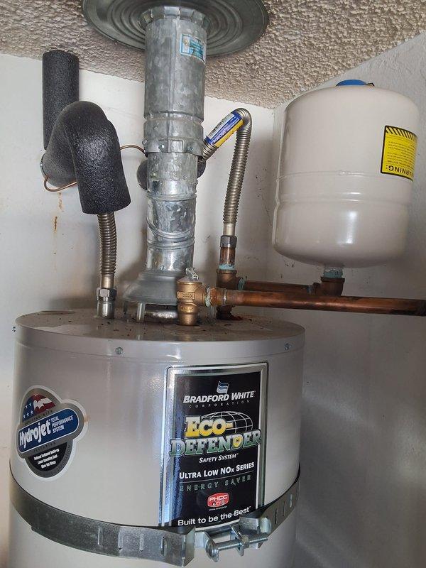 Responded to a warranty callback for a recurring Error Code 10 lockout on a Bradford White gas-fired water heater following a prior pilot relight. Inspected the gas control valve, burner compartment, flue and venting, then relit the pilot and verified stable ignition and proper burner operation. Confirmed the unit was heating normally with no further fault codes present after the repair.