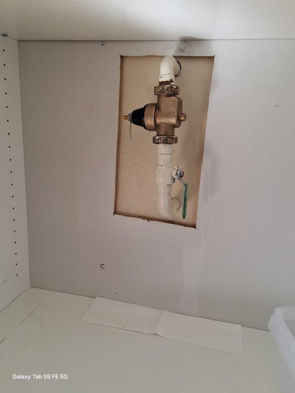 Responded to a warranty call for a leak at the shut-off ball valve on the water conditioning unit's plumbing assembly. Accessed the plumbing through the wall cutout, inspected the ball valve and connecting PVC fittings, and corrected the leak at the valve connection. Verified the assembly was dry and holding pressure with no further leaks.