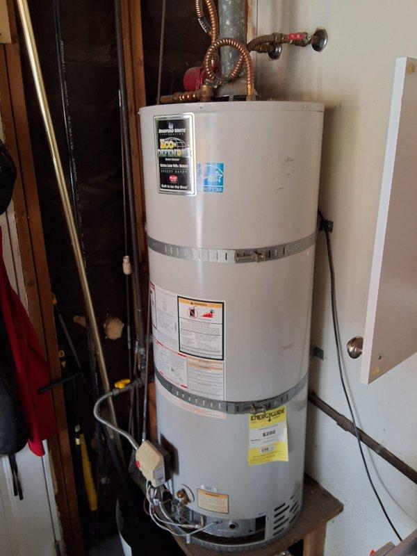 Performed an on-site inspection of the existing 50-gallon natural gas water heater to evaluate it for replacement and prepare an estimate for a Bradford White URG250T6N unit. Documented the installation, including the strapping, gas control valve and flexible gas connector, vent connection, copper supply and shutoff valves, and platform mounting, and found no visible rust, leaks, or tank damage. Existing unit data plate details and permit requirements were not confirmed, so the replacement scope is pending verification of those items.