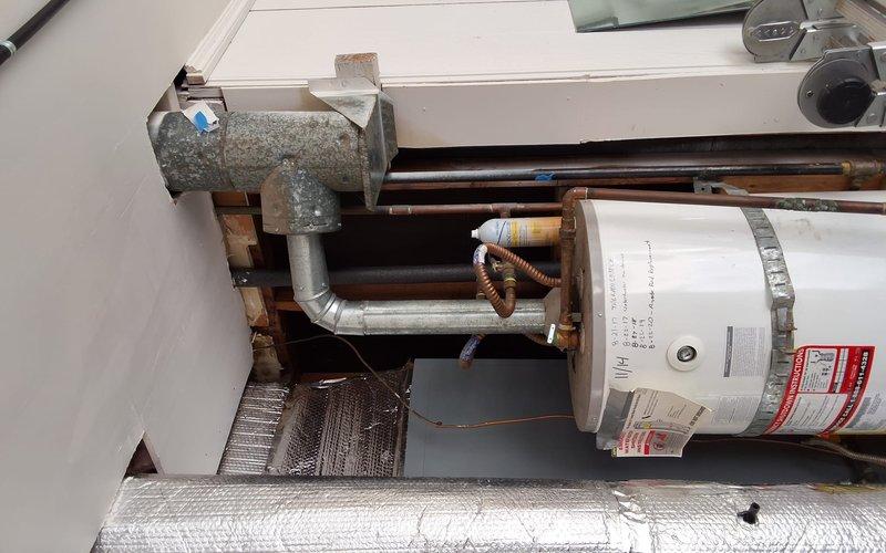 Inspected the existing 40-gallon gas water heater, including the vent connector, flue assembly, copper supply piping, and tank strapping, and prepared a replacement estimate for a 40- or 50-gallon unit at the customer's request. Documented the installation conditions in a confined utility space, noting weathered galvanized venting and cluttered surroundings that will need to be cleared prior to work. Reviewed permit requirements and presented all replacement options, including a pressure-mitigating accessory, and discussed available payment methods with the customer.
