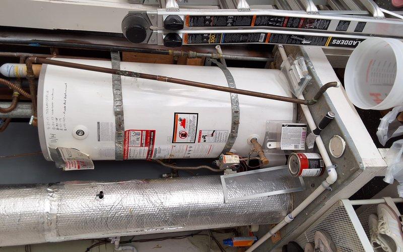 Inspected the existing 40-gallon gas water heater, including the vent connector, flue assembly, copper supply piping, and tank strapping, and prepared a replacement estimate for a 40- or 50-gallon unit at the customer's request. Documented the installation conditions in a confined utility space, noting weathered galvanized venting and cluttered surroundings that will need to be cleared prior to work. Reviewed permit requirements and presented all replacement options, including a pressure-mitigating accessory, and discussed available payment methods with the customer.