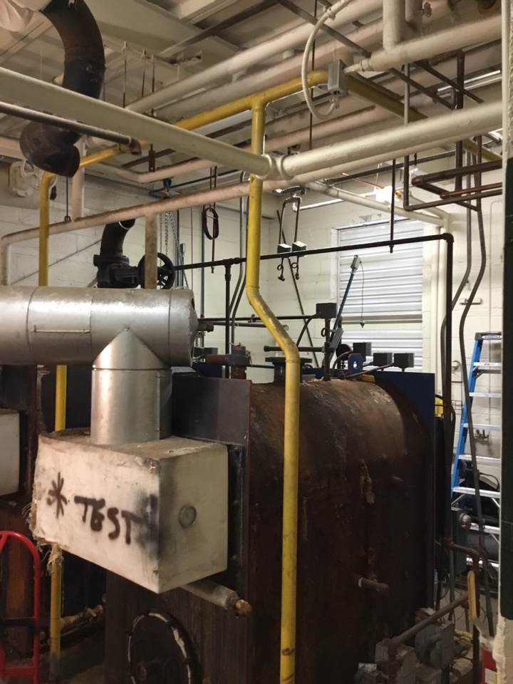 Demoing existing water supply and return lines in boiler room