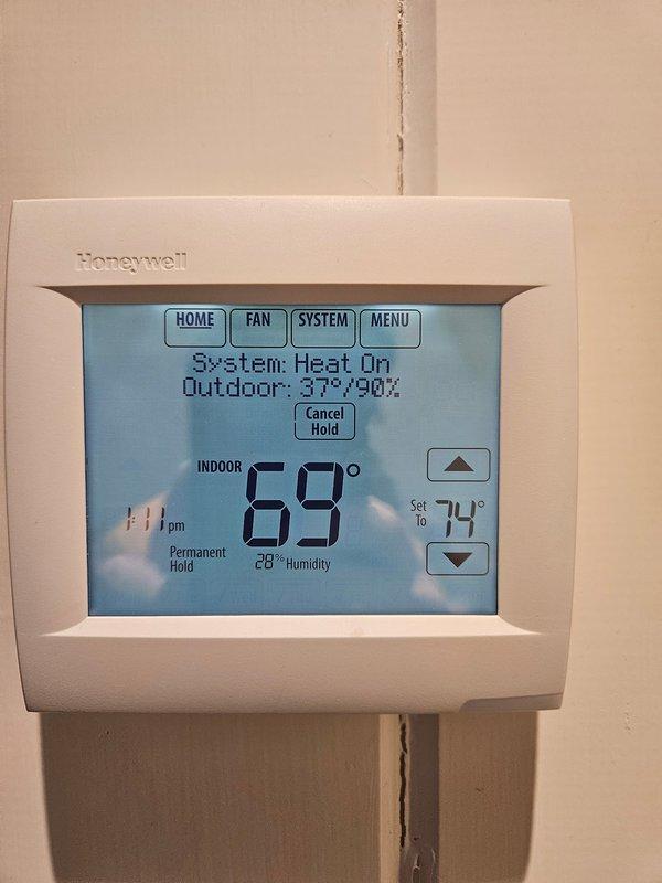 Responded to humidity issue in residence with 28% indoor humidity reading on Honeywell thermostat. Inspected property and documented damage to wooden elements including peeling wood and splitting walls. Observed window frame damage with paint chipping and exposed underlying wood, consistent with low humidity conditions.