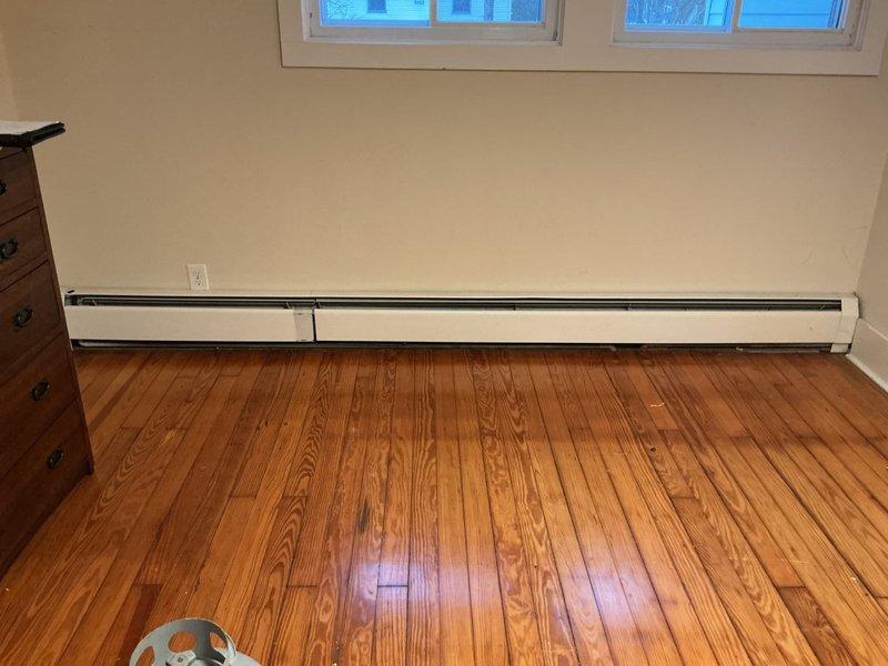 Conducted on-site estimate for replacement of damaged boiler system due to frozen radiators. Assessed existing baseboard heating units and associated piping infrastructure. Provided separate quotation options for complete HVAC system installation with air conditioning capability, as requested by customer. Documentation includes photographs of the affected areas showing baseboard heaters and exposed copper piping requiring replacement.