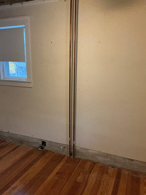 Conducted on-site estimate for replacement of damaged boiler system due to frozen radiators. Assessed existing baseboard heating units and associated piping infrastructure. Provided separate quotation options for complete HVAC system installation with air conditioning capability, as requested by customer. Documentation includes photographs of the affected areas showing baseboard heaters and exposed copper piping requiring replacement.