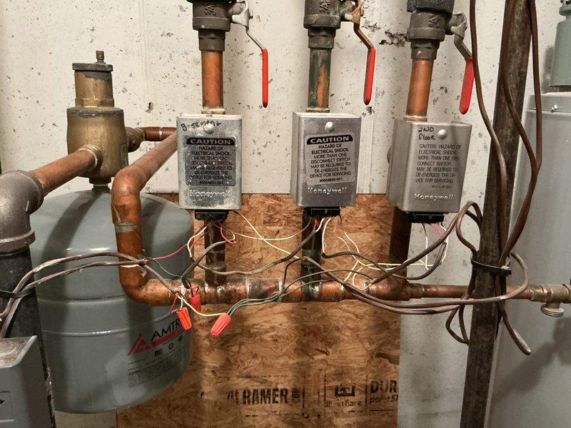 Completed estimate for replacement options of an aging water heater installed in basement utility area. Additionally assessed property for multi-head mini split system installation, documenting existing mechanical infrastructure including Honeywell control boxes and Amtrol expansion tank connected to copper plumbing network.