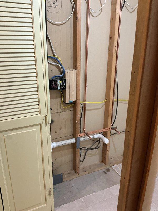 Completed bathroom renovation including demolition of cast iron tub, disconnection of water lines for tub and lavatory, and removal of toilet. Installed new 5' fiberglass shower unit with proper rough-in plumbing, requiring modification of existing copper supply lines and PVC drain connections as documented in photos of framing work.