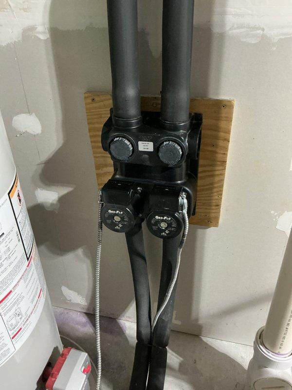 Provided estimate for adding zones to existing geothermal HVAC system. Assessed current basement mechanical setup including white air handler unit, geothermal manifold assembly with dual control valves, galvanized metal ductwork throughout exposed ceiling joists, and associated PEX plumbing connections. Documented existing system configuration with photographs to determine zoning requirements and integration points for additional zone controls with the current geo system infrastructure.