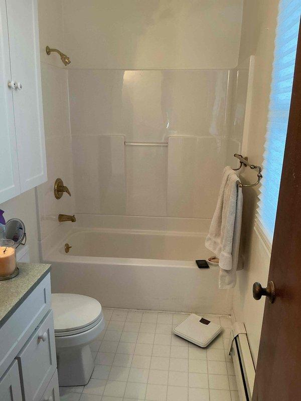 Conducted on-site assessment of upstairs bathroom for potential conversion to laundry room. Evaluated existing plumbing infrastructure including bathtub-shower combination unit with brass fixtures, toilet, and vanity with water supply and drain lines. Documented current bathroom layout and plumbing configuration to provide accurate quote for relocating water supply lines, drain connections, and venting required for washer and dryer installation.