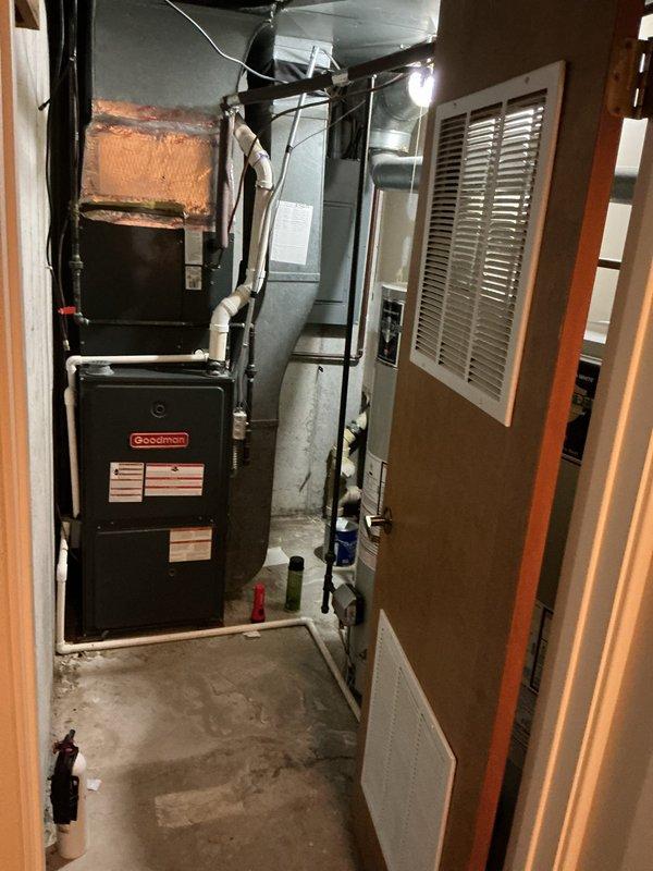 Performed on-site assessment of existing water heater requiring replacement in basement utility area. Evaluated current 40-gallon unit installation, documented all plumbing connections including galvanized and copper supply lines, PVC drainage system, and electrical requirements. Photographed equipment configuration and surrounding mechanical room infrastructure to provide accurate replacement estimate and ensure proper sizing for new unit installation.