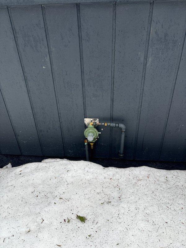 Provided estimate for natural gas piping installation to supply Generac standby generator mounted on concrete pad. Gas line will run approximately 5 feet from existing LP tank regulator to generator connection point, with all components located on same side of building for efficient routing.