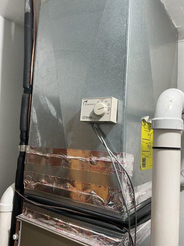 Conducted on-site evaluation for steam humidifier replacement on residential HVAC system. Assessed existing air handler unit showing significant surface condensation and moisture issues, with current humidistat control mounted on exterior. Documented equipment condition including exposed insulation requiring attention and existing drainage/venting configuration with PVC piping. Evaluated mechanical equipment installation in basement area, identifying aging infrastructure with moisture-related staining on surrounding walls and rust indicators. Photographed copper piping connections, electrical wiring, and overall system layout to provide comprehensive estimate for steam humidifier replacement and associated components.