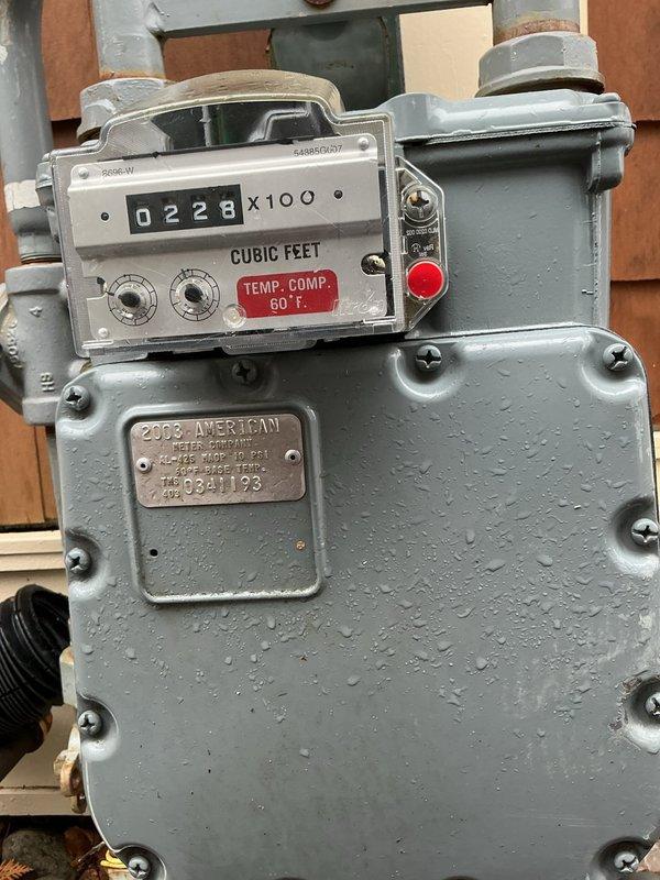 Conducted on-site assessment for replacement of two furnaces at residential property. Documented existing natural gas meter installation showing American brand meter dated 2005 with current reading of 0228 cubic feet, temperature compensated to 60°F. Verified gas supply infrastructure and connection points for future furnace installations. Photographed exterior electrical service panel configuration including main meter and multiple junction boxes to assess electrical capacity for new heating equipment. Evaluated utility access points and existing infrastructure to determine installation requirements and compatibility with proposed HVAC systems. Property accessed per client arrangement with findings documented through photographic evidence for estimate preparation.