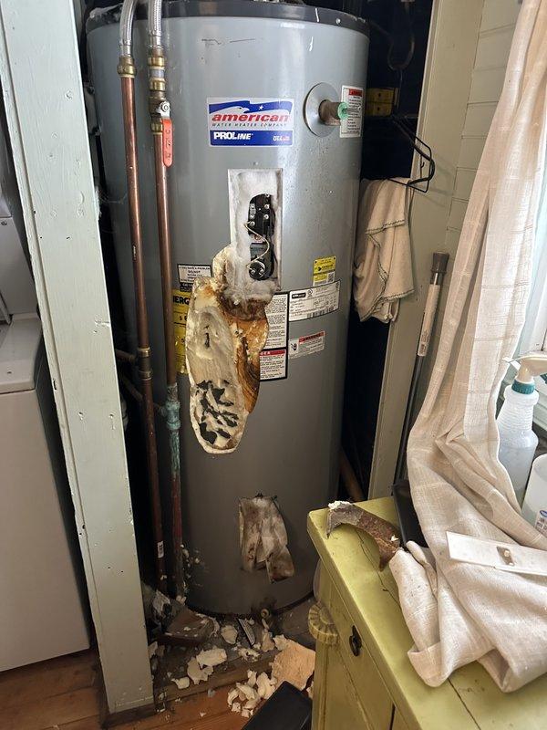 Performed comprehensive assessment of existing American Standard PROLINE water heater exhibiting severe corrosion, rust damage, and deteriorated insulation on lower tank sections, likely resulting from improper winterization and inadequate drainage procedures. Documented extensive water damage, mineral deposits, and structural compromise to tank exterior and insulation materials. Provided estimate options for replacement with 50-gallon and 80-gallon conventional tank water heaters, as well as tankless water heater alternative. Assessed plumbing system for additional freeze damage or compromised components throughout property due to improper seasonal shutdown. Prepared quote for water softener system installation to replace existing treatment equipment. Photographed damage conditions including rust staining, insulation failure, and debris accumulation at unit base for documentation and estimate preparation.